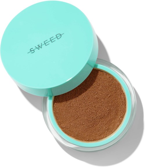A round, light blue container with a lid reading "SWEED" contains brown powder. The lid is partially open.