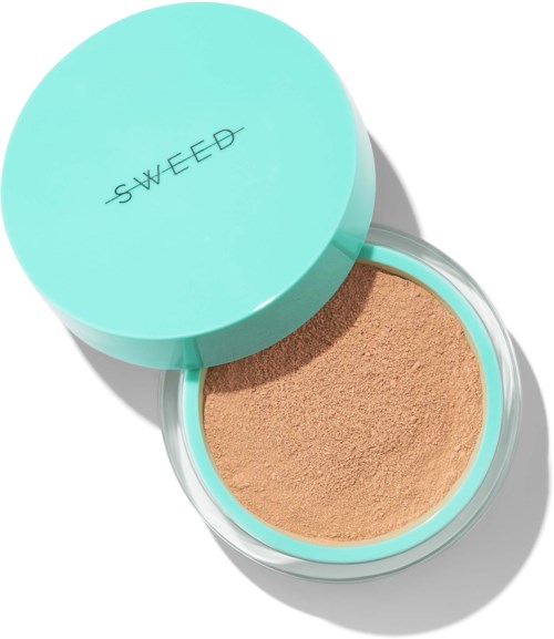 A round mint green container labeled 'SWEED' with beige powder inside. The container's lid is partly open.