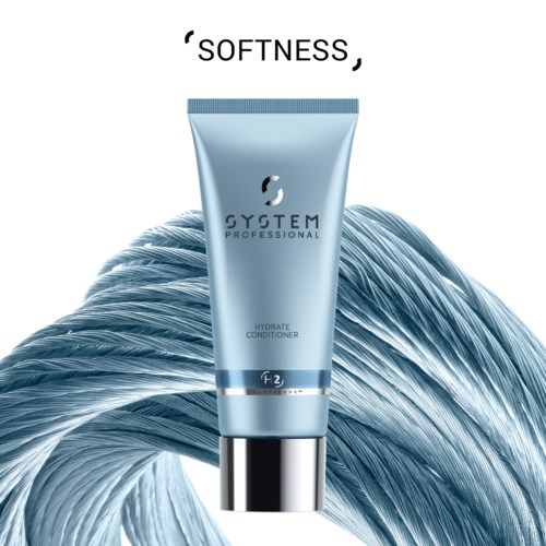 Tuber met blauw label 'Gystem Professional' op een glanzend metalen oppervlak met stromend haar op de achtergrond.
