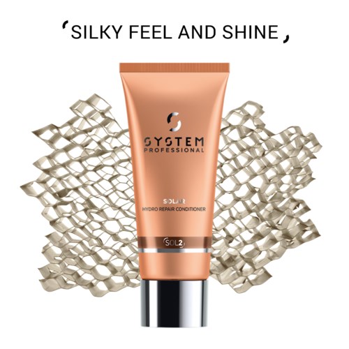 Een perzikkleurige tube met 'System Professional' en 'Solar Hydro Repair Conditioner', zilveren dop en decoratieve achtergrond.