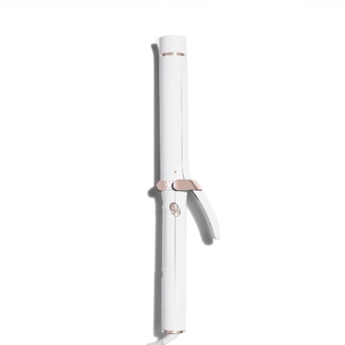 A white curling iron with a pink handle and clamp, standing upright on a white background.