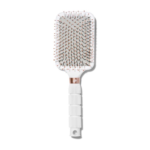 A white hairbrush with numerous orange-tipped pins and a handle with grooves.