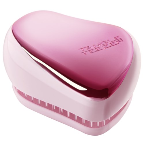 En rosa hjärtformad enhet med orden "TANGLE TEEZER" på toppen, används för hårborstning.