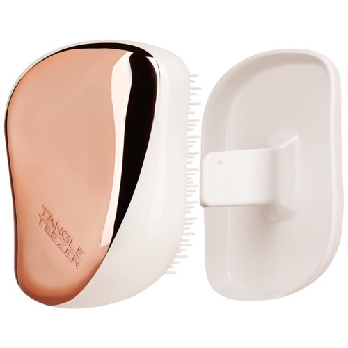 A wall-mounted magnifying mirror with a white base and a round, beige reflective surface. Includes a detachable magnetic magnifier.