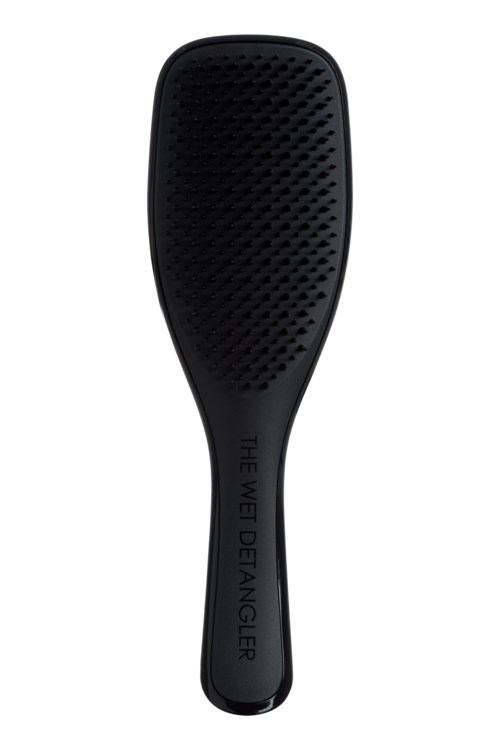 A black grooming tool with a wide, textured surface and a handle labeled 'THE WET DANGER.'