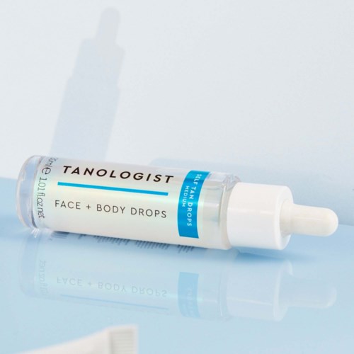 Mała buteleczka z napisem 'Tanologist Face + Body Drops' i kroplomierzem na jasnym tle.