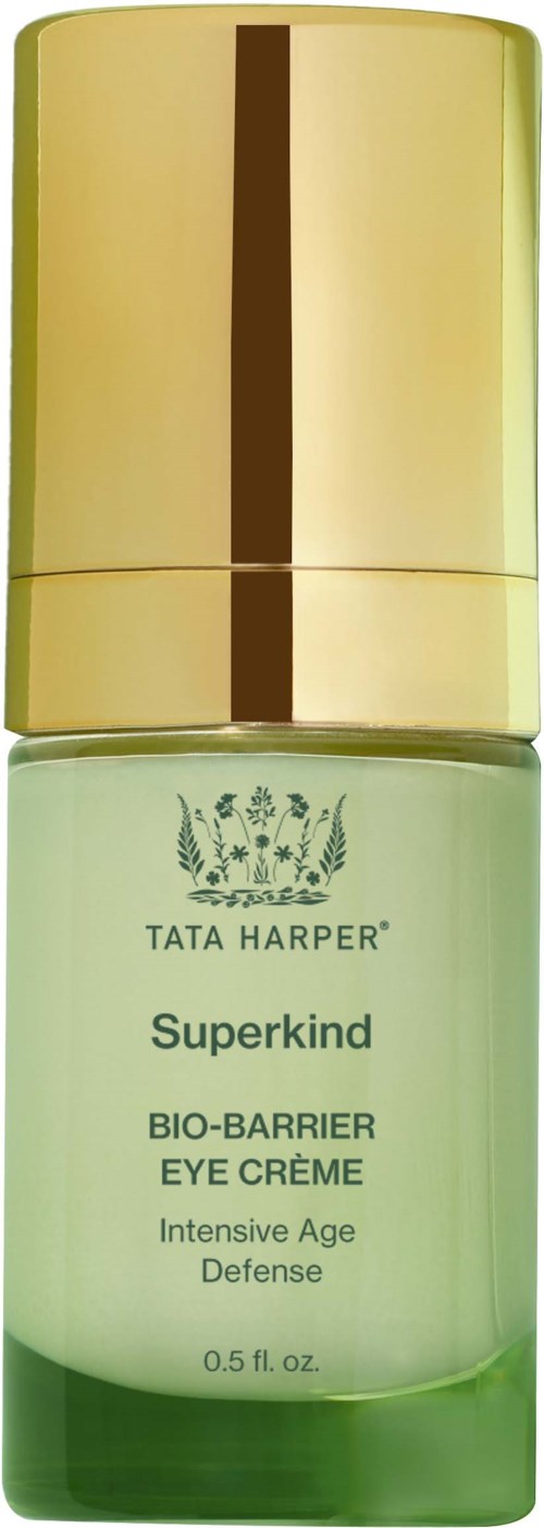 A small green bottle with a gold cap, labeled Tata Harper Superkind Bio-Barrier Eye Crème for age defense.