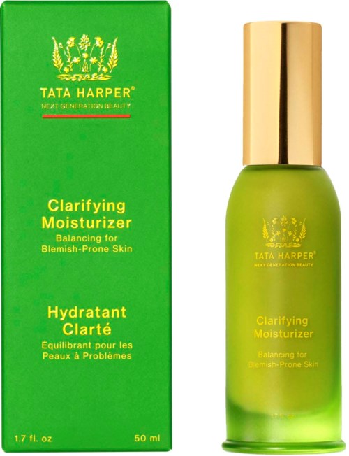 A green and yellow bottle with a gold cap, next to a green box, both labeled Tata Harper Clarifying Moisturizer.