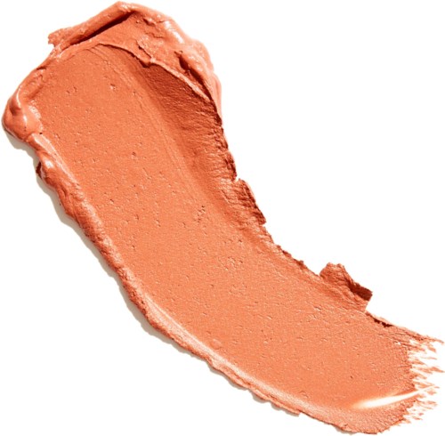 A peach-colored cosmetic cream spread in a curved shape on a white background.