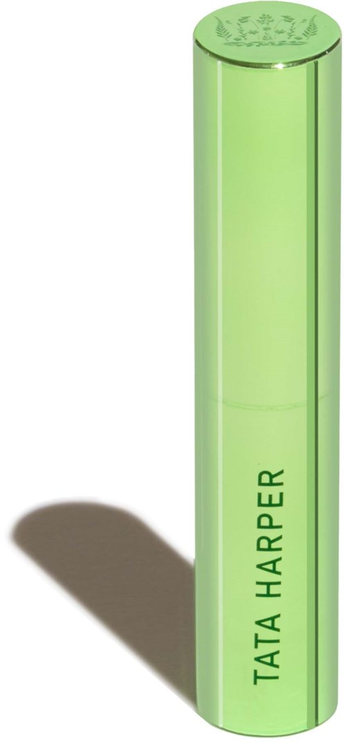 A tall, green, cylindrical object with "TATA HARPER" written vertically on it, casting a shadow.