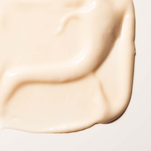 Creamy, smooth substance spread on a surface, possibly lotion or skincare product.
