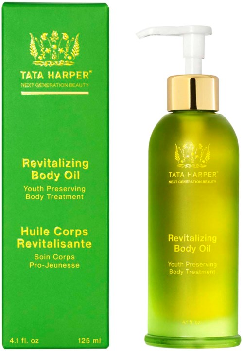 A green box and a matching green pump bottle containing Tata Harper Revitalizing Body Oil for youthful skin.
