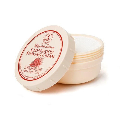 A round container of Cedarwood Shaving Cream with a lid showing a red and white label. The lid is partly open.