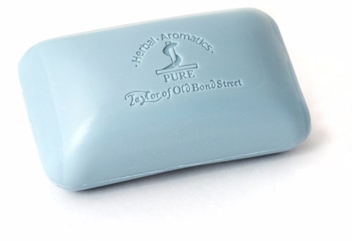 A light blue soap bar with a label that reads 'Herbal Aromatics, PURE, Taylor of Old Bond Street.'