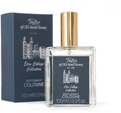 A glass bottle of cologne, gold cap, with a blue label and box showing a building and text.