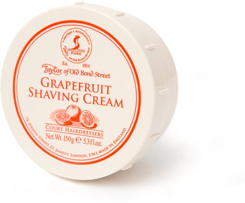 A round container labeled grapefruit shaving cream, made in England, with red and orange text and images of grapefruits.