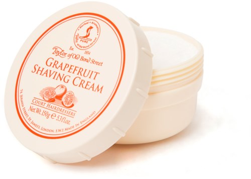 A round container with a lid that says grapefruit shaving cream, featuring an illustration of grapefruits.