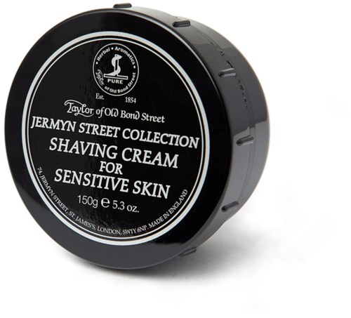 A black round container with a lid. It has white text and logo for a shaving cream for sensitive skin.