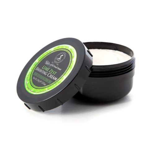 A black container with a green label contains white shaving cream, with the lid slightly open.