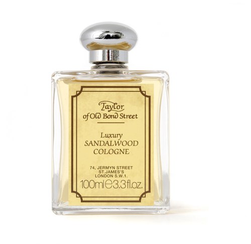 A clear perfume bottle with a gold label and silver cap, containing sandalwood cologne.