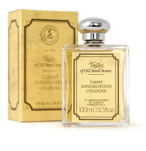 A clear perfume bottle with gold-colored perfume, and box with similar design and text.