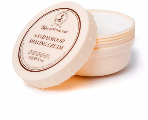 Round container with cream labeled as sandalwood shaving cream, partially open showing white cream inside.