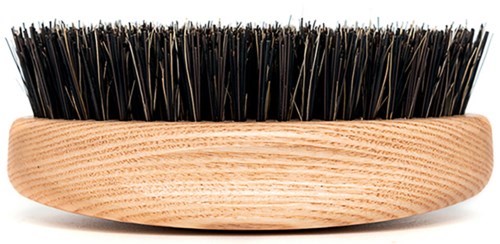 Eine Holzborste mit schwarzen Borsten, verwendet zum Reinigen oder Pflegen.