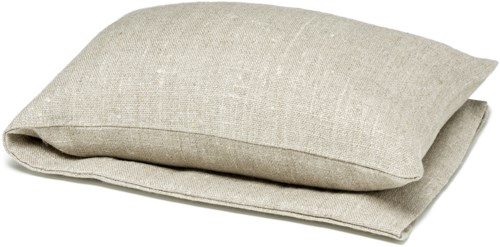 Et sammenrullet beige linpute og teppe ligger på en enkel hvit bakgrunn.