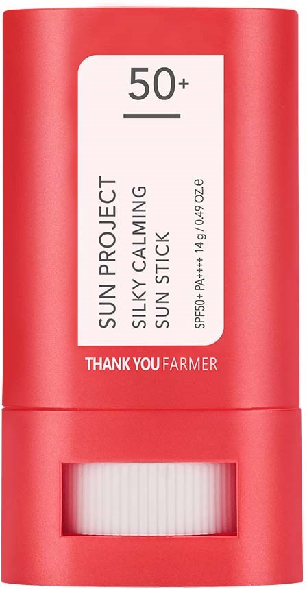 A red cylindrical bottle with a white label mentioning SPF 50+ and calming sun stick.