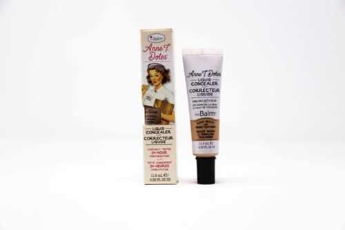 Eine Tube flüssiger Abdeckcreme mit Vintage-Verpackung und passender Schachtel, beide für Hautabdeckung.