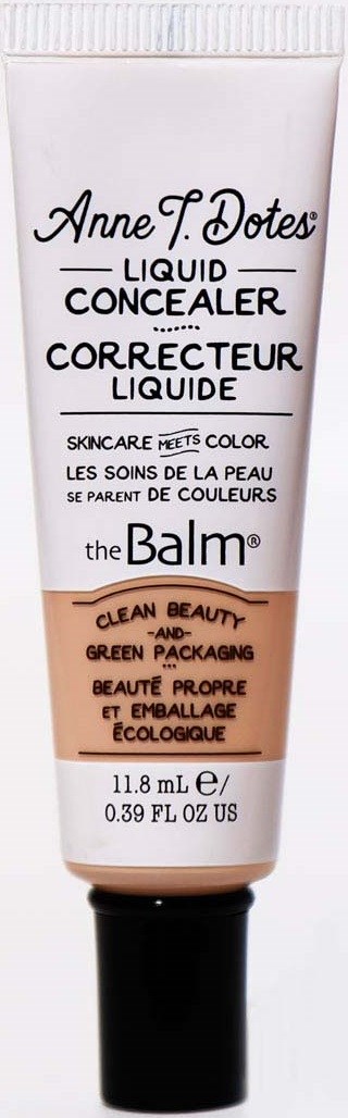 Eine Tube flüssiger Concealer von theBalm mit beiger Farbe, schwarzem Deckel und schwarzem Text. Es erwähnt Hautpflege und umweltfreundliche Verpackung.