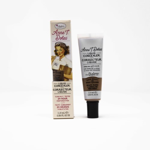 Eine Tube flüssiger Abdeckcreme neben einer Verpackung mit einer Vintage-Frau und Produktdetails.
