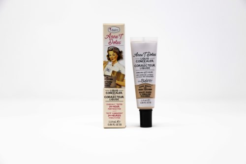 Een tube vloeibare concealer met een vintage vrouwenillustratie en bijpassend doosje op een witte achtergrond.