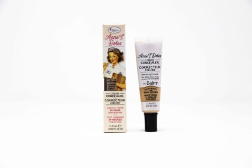 Een tube vloeibare concealer en de bijbehorende doos met vintage-stijl kunstwerk en productinformatie.