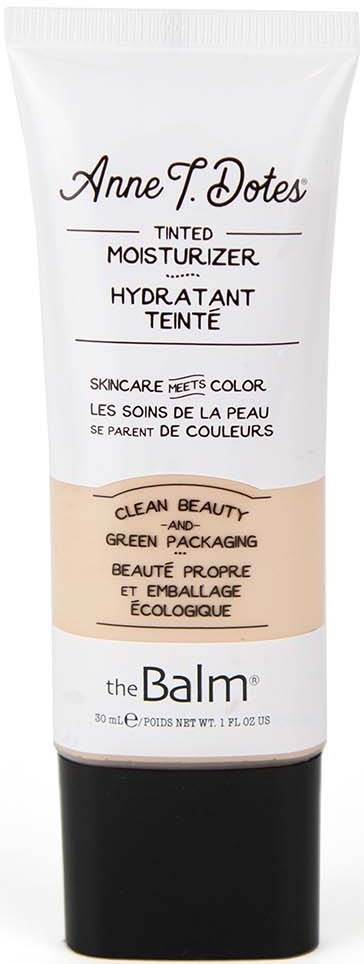 En tub med tonad fuktighetskräm med vit och svart design, märkt "Anne T. Dotes" och "the Balm."