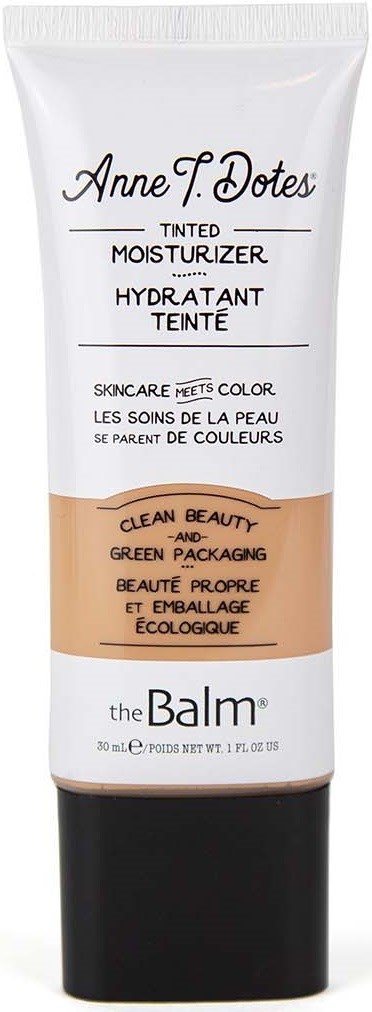 En vit tub med färgad dagkräm med svart lock, märkt med varumärke och produktinformation, med beige och svarta sektioner.