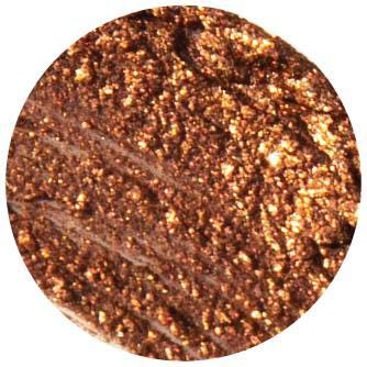 Een close-up van een bruine, textuurrijke oppervlakt met goudglitters, mogelijk een make-upproduct of cosmetica. Het bevat glanzende, glitterende deeltjes.