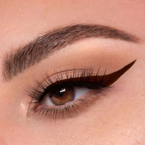 Close-up van een oog met gedetailleerde make-up, inclusief bruin oogschaduw, Liner en lange wimpers.