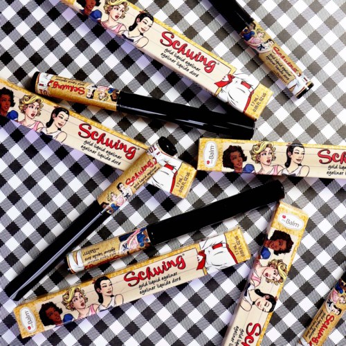 Lippenbalsems met cartoon-prinsessen ontwerpen liggen verspreid op een zwart-wit ruitjesoppervlak.