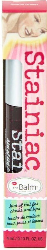 Lippenbalsemstift met roze en witte ontwerp, met een vrouw bovenaan, gelabeld "Stainiac" door theBalm.