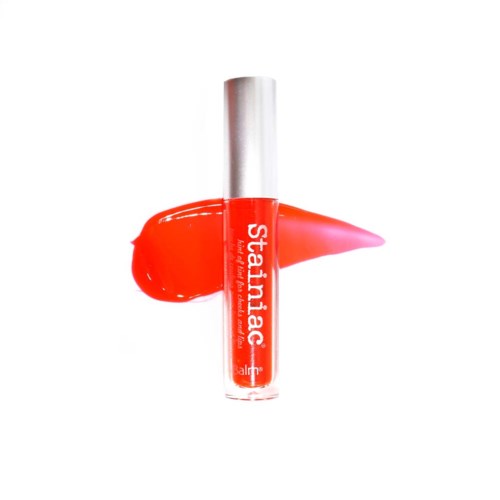 Lippenbalsemtube met rode kleur en zilveren dop, met gloss verspreid in de buurt.