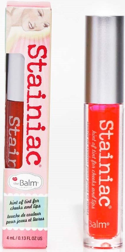 Een lippenfaringproduct genaamd 'Stainiac' met roze verpakking, een zilveren dop en zichtbare lipgloss binnenin.