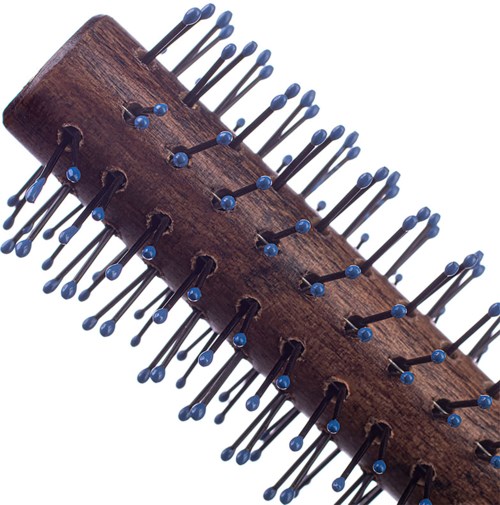 A wooden racquet with many small blue-tipped pins or nails protruding from it.