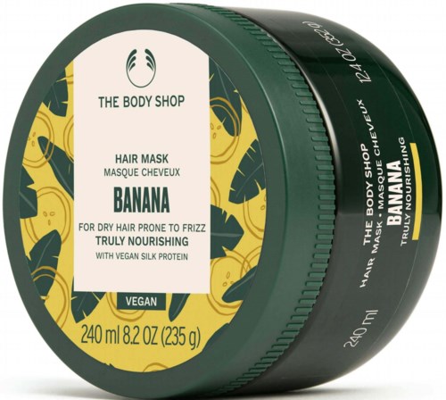 Ein grüner und gelber Behälter von The Body Shop Bananen-Haarmaske für trockenes Haar. Enthält veganes Seidenprotein.