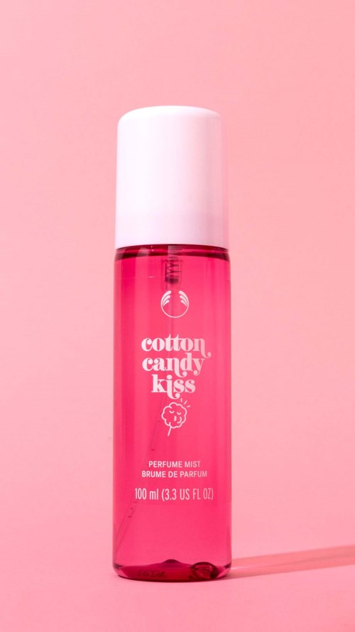 Pinkes Sprayflasche mit der Aufschrift 'cotton candy kiss' Parfüm Mist auf pinkem Hintergrund.