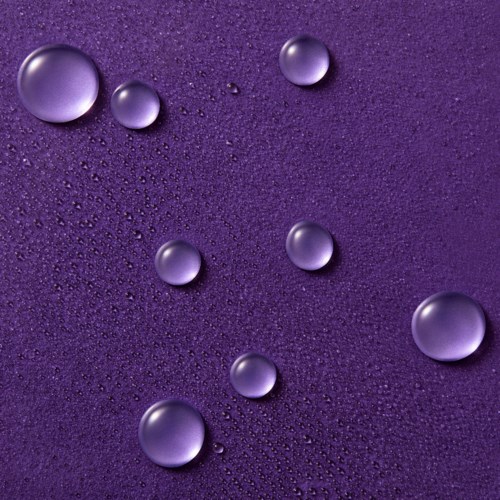 Violetin taustalla on erilaisia vesipisaroita, jotka on levitetty pinnalle.