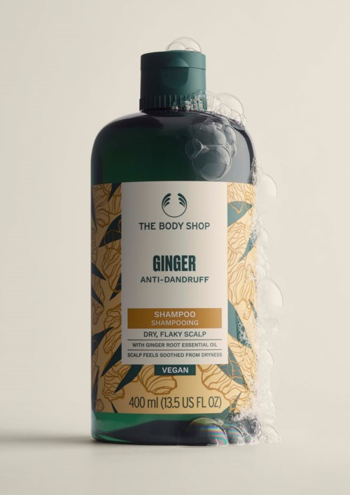 Grüne Flasche mit Ingwer-anti-Schuppen-Shampoo mit beiger Etikett und grünem Klappverschluss.