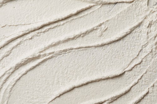 Creamy textured skincare or makeup product with visible brush or application strokes.