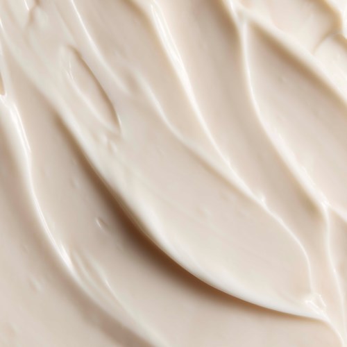 Creamy, beige-colored skincare product with soft, smooth texture.