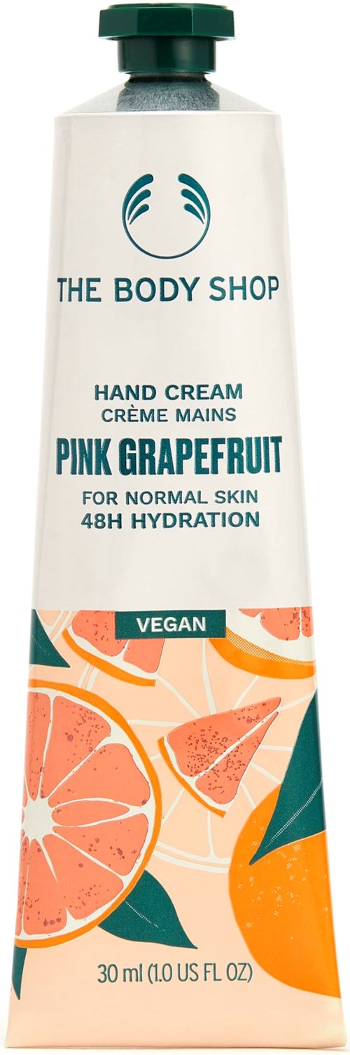 A tube of hand cream with grapefruit fruit illustrations and green cap, featuring The Body Shop logo and vegan label.